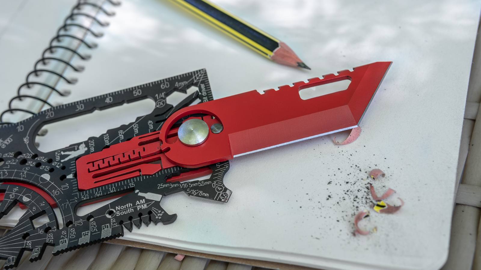Red Rotate Lock KIT module mounted in the slot of a black Universal card, on a sketchbook next to a pencil