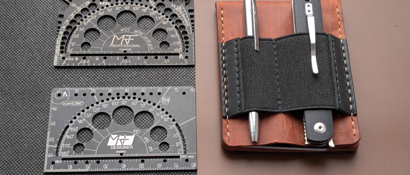 Professional and Designer cards next to a brown leather MRF holder loaded with a pen and a folding knife under its elastic loops
